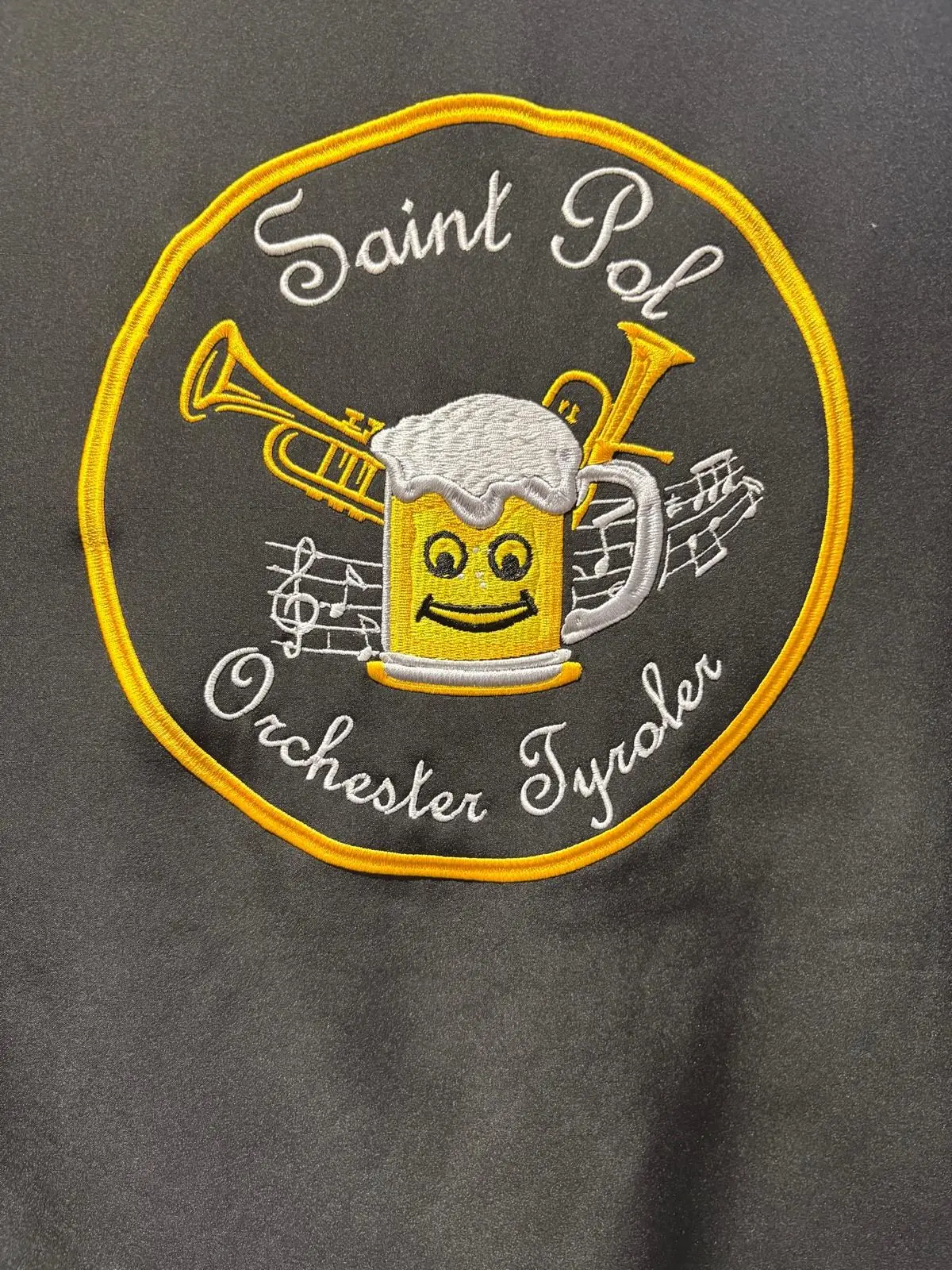 Écusson rond brodé « Saint Pol Orchester Tyroler » avec une chope de bière, des trompettes et des notes de musique